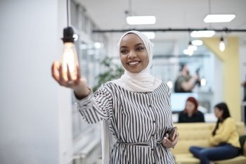 internet of things concept woman holding hands around bulb smart saving energy wearing hijab as traditional muslim