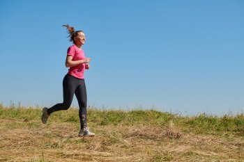 woman  jogging in a healthy lifestyle on a fresh mountain air at beautiful sunny summer nature