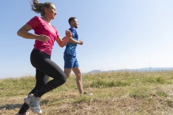 couple jogging in a healthy lifestyle on a fresh mountain air at beautiful sunny summer nature