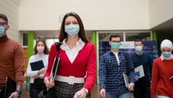 multiethnic students group walking on university coridor wearing protective face mask in new normal coronavirus pandemic lifestyle in education