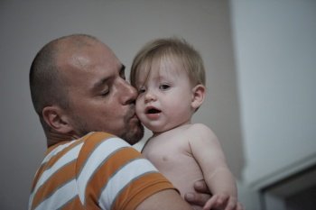 father holding and kissing newborn little baby concept of fatherhood