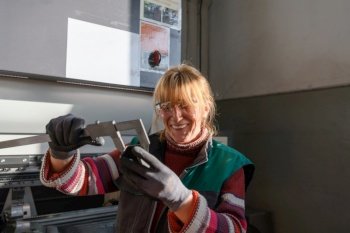 a woman working in a modern factory for the production and processing of metals, preparing and measures materials that go to the processing of CNC machines. High quality photo. a woman working in a modern factory for the production and processing of metals, preparing and measures materials that go to the processing of CNC machines
