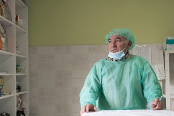 Mature confident animal doctor or veterinary portrait standing in surgery room - selective focus. High quality photo. Mature confident doctor standing in front of surgery room - focus on the face