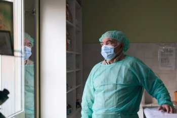 Mature confident animal doctor or veterinary portrait standing in surgery room - selective focus. High quality photo. Mature confident doctor standing in front of surgery room - focus on the face