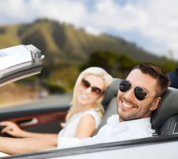 road trip, travel and people concept - happy couple driving in convertible car outdoors. happy couple driving in convertible car