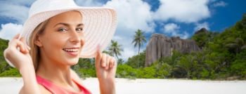 travel, summer holidays and tourism concept - portrait of beautiful smiling woman in sun hat over beach on seychelles island background. portrait of smiling woman in sun hat over beach