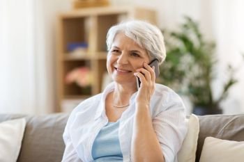 technology, communication and people concept - happy senior woman calling on smartphone at home. senior woman calling on smartphone at home