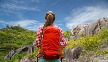 adventure, travel, tourism, hike and people concept - young woman with backpack over background of seychelles island. woman with backpack over seychelles island