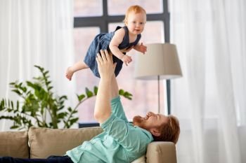 family, fatherhood and people concept - happy red haired father with little baby girl at home. happy father with little baby girl at home