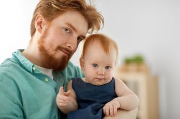 family, fatherhood and people concept - portrait of red haired father with little baby daughter at home. portrait of father with little baby daughter