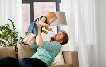 family, fatherhood and people concept - happy red haired father with little baby girl at home. happy father with little baby girl at home
