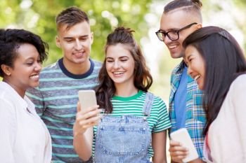 friendship, technology and international concept - group of happy smiling with smartphone outdoors. group of happy friends with smartphone outdoors