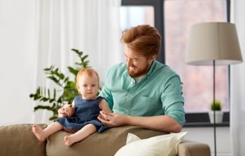 family, fatherhood and people concept - happy red haired father with little baby daughter at home. happy father with little baby daughter at home