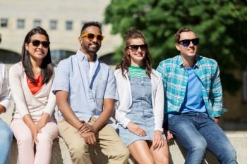 people, friendship and international concept - group of happy smiling friends in sunglasses in city. group of happy friends in sunglasses in city