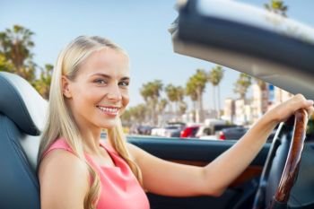 travel, road trip and people concept - happy young woman driving convertible car over venice beach background in california. woman driving convertible car over venice beach