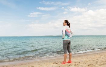 fitness, sport and healthy lifestyle concept - woman in sports clothes on beach. woman in sports clothes on beach
