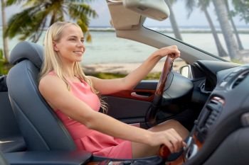 travel, road trip and people concept - happy young woman driving convertible car over tropical beach background in french polynesia. happy woman driving convertible car over beach