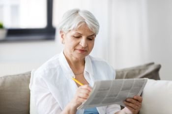 age and people concept - senior woman marking newspaper ad at home. senior woman marking newspaper ad at home