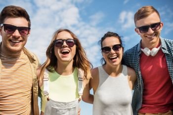 leisure, people and friendship concept - happy teenage friends laughing outdoors in summer. happy teenage friends laughing outdoors in summer