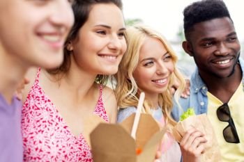 leisure and people concept - happy friends with takeout food outdoors. happy friends with takeout food outdoors