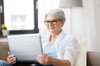 technology, old age and people concept - happy senior woman in glasses with laptop computer at home. happy senior woman with on laptop computer at home