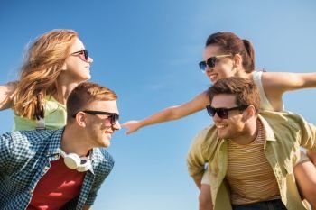 leisure, people and friendship concept - happy teenage friends having fun outdoors in summer. happy teenage friends having fun in summer