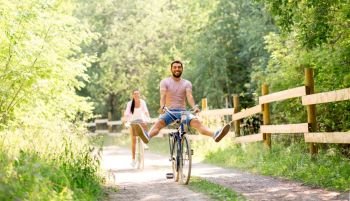 cycling, leisure and lifestyle concept - happy young couple with bicycles at summer park. happy couple with bicycles at summer park