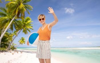 leisure, summer holidays and people concept - smiling teenage girl in sunglasses with ball over tropical beach background in french polynesia. smiling teenage girl in sunglasses with beach ball