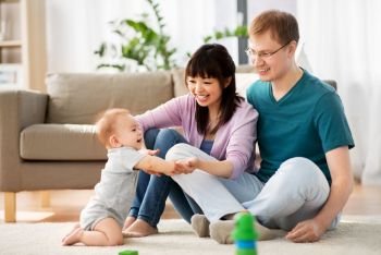 family, parenthood and people concept - happy mother and father with baby boy at home. happy family with baby boy at home