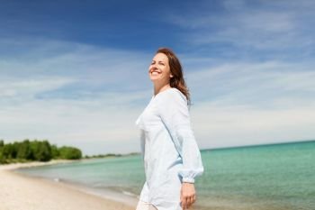 people and leisure concept - happy smiling woman on summer beach. happy smiling woman on summer beach