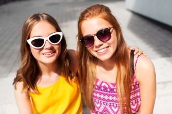 summer fashion, eyewear and people concept - smiling teenage girls in sunglasses outdoors. smiling teenage girls in sunglasses outdoors
