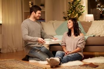 leisure, hygge and people concept - happy couple with food on tray at home. happy couple with food on tray at home