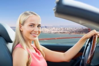 travel, road trip and people concept - happy young woman driving convertible car over golden gate bridge in san francisco bay background. woman driving convertible car in san francisco