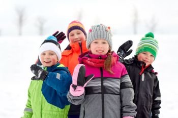 childhood, friendship and season concept - group of happy little kids in winter clothes outdoors. happy little kids in winter clothes outdoors