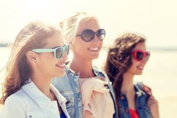 summer vacation, holidays, travel and people concept - group of smiling young women in sunglasses and casual clothes on beach. group of smiling women in sunglasses on beach