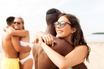 friendship, summer holidays and love concept - happy mixed race couple hugging on beach. happy mixed race couple hugging on beach