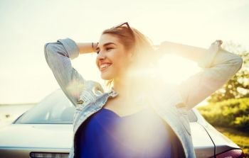 summer vacation, holidays, travel, road trip and people concept - happy smiling teenage girl or young woman near car at seaside. happy teenage girl or young woman near car