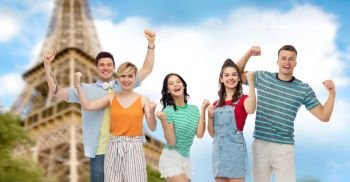 travel, tourism and summer holidays concept - group of happy smiling friends making fist pump gesture over eiffel tower background. friends making fist pump gesture over eiffel tower