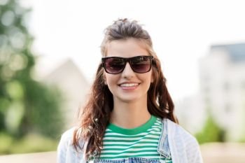 summer, eyewear and people concept - portrait of happy smiling young woman or teenage girl in sunglasses outdoors. portrait of young woman in sunglasses outdoors