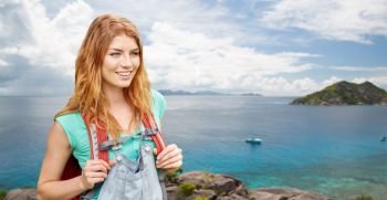 adventure, travel, tourism, hike and people concept - smiling young woman with backpack over background of seychelles island in indian ocean. happy woman with backpack over seychelles island