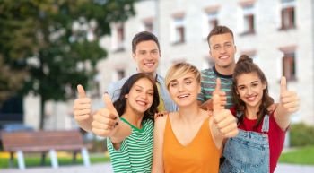 education, gesture and people concept - group of happy smiling friends showing thumbs up over school or campus background. happy friends showing thumbs up