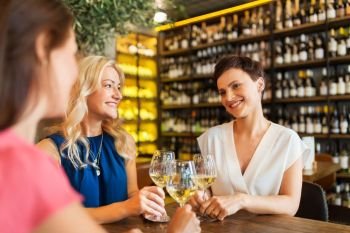 people, celebration and lifestyle concept - happy women drinking wine and clinking glasses at bar or restaurant. happy women drinking wine at bar or restaurant