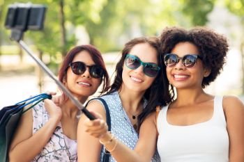 sale, friendship and technology concept - happy young women with shopping bags taking selfie by smartphone in outdoors. women with shopping bags taking selfie outdoors