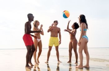 friendship, summer holidays and people concept - happy friends playing with inflatable ball on beach. friends playing with beach ball in summer