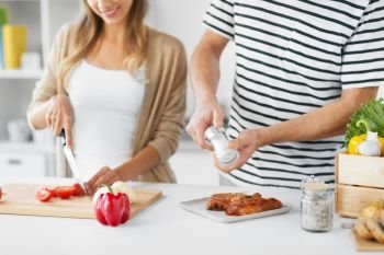 culinary, people and healthy eating concept - close up of couple cooking together at home kitchen. couple cooking food together at home