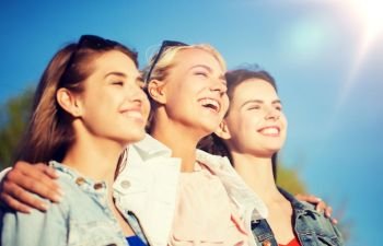 summer vacation, holidays, friendship and people concept - group of happy smiling young women or teenage girls hugging outdoors. happy women or teenage girls hugging outdoors