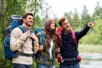 travel, tourism, hiking and people concept - happy friends or travelers with backpacks. happy friends or travelers with backpacks hiking