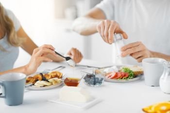 food and eating concept - close up of couple having breakfast at home. close up of couple having breakfast at home