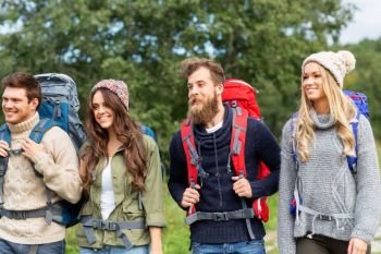 travel, tourism, hiking and people concept - group of smiling friends with backpacks. friends or travelers with backpacks hiking