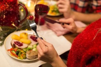 holidays, food and celebration concept - close up of woman having christmas dinner and eating. close up of woman having christmas dinner
